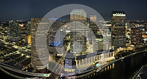 View from above of illuminated skyscraper buildings, pedestrian riverwalk and street traffic in downtown of Tampa city