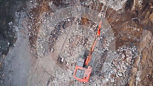 View from above. A large excavator dismantles the concrete base.