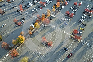 View from above of many parked cars on parking lot with lines and markings for parking places and directions. Place for