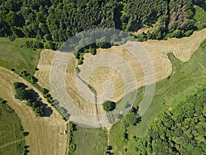 View from above of mowed grass fields with hay bales and trees