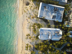 View from above. Palm trees on the sandy beach, hotels, swimming pools, clear warm turquoise sea. Beautiful seascape, resort