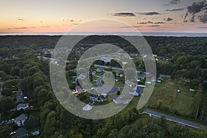 View from above of residential houses in living area in Rochester, NY at sunset. Illuminated american dream homes as