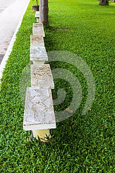 A view from above on rows of old white marble benches laid out on a verdant green lawn