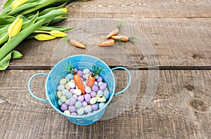 View from above of small blue bucket filled with candy eggs and