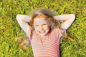 View from above of smiling girl laying on grass