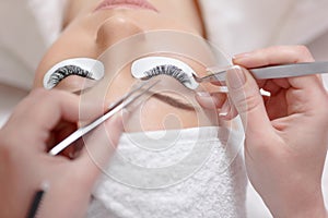 View from above of stylist lengthening lashes.