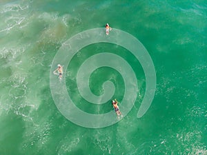 A view from above of the surfers in the ocean