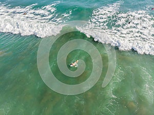 A view from above of the surfers in the ocean