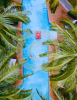 View from above at a swimming pool, couple men and women in swimming pool, drone view