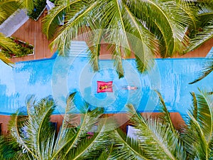 View from above at a swimming pool, couple men and women in swimming pool, drone view