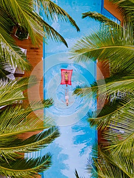 View from above at a swimming pool, couple men and women in swimming pool, drone view