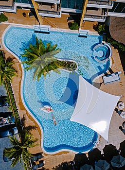 View from above at a swimming pool, couple men and women in swimming pool, drone view