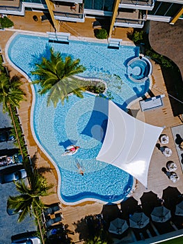 View from above at a swimming pool, couple men and women in swimming pool, drone view