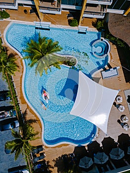 View from above at a swimming pool, couple men and women in swimming pool, drone view