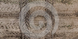 view from above on texture of wet muddy road with tractor tire tracks in countryside