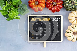 View from above to simple September 2024 calendar decorated with pumpkin