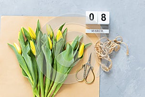 View from above tulips on craft paper and gray concrete background. Mockup for womens day, 8 March. Flat lay style, top