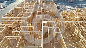 View from above of unfinished frame of apartment condo with wooden roof beams under construction. Development of