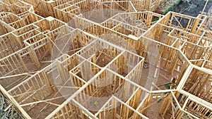 View from above of unfinished frame of apartment condo with wooden roof beams under construction. Development of