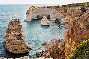 View from above from the viewpoint of the natural arches. . Orange cliffs and turquoise waters. Concept of tourism and travel.