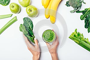 View from above woman's hands holding bunch spinach