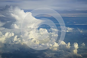 View of abstract dense soft fluffy white cloud copyspace with shades of blue sky and earth background from above flying airplane