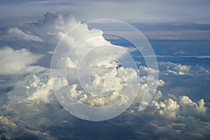 View of abstract dense soft fluffy white cloud with shades of blue sky and earth background from above flying plane window