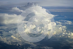 View of abstract soft fluffy white cloud with shades of blue sky and earth background from above flying plane window