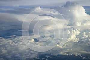 View of abstract soft free form wind blow white cloud with shades of blue sky background from above flying plane window