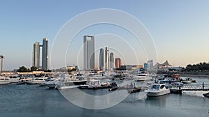 View of Abu Dhabi city corniche and beach - Adnoc headquarters and Nation towers - boats and marina