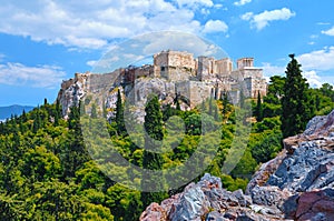 View of Acropolis hill from Areopagus hill on summer day with great clouds in blue sky, Athens, Greece. UNESCO world