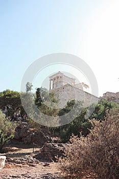 View of the Acropolis and the Temple of Athena Nike in Athens, Greece with lush green trees