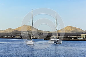 A view across the bay in Arrecife, Lanzarote towards moored yachts and the volcanic landscape as a backdrop