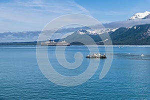 A view across Disenchartment Bay towards icebergs and a cruise ship in Alaska
