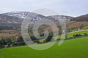 A view across one of the many snow topped hills and valleys of the Mourne Mountains in County down in Northern Ireland on a dull m