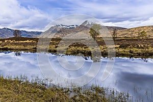 A view across Rannoch Moor and in the shallow waters of Loch Ba near Glencoe, Scotland