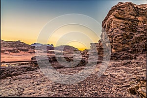 A view across the rocky terain of the desert landscape in Wadi Rum, Jordan at sunset
