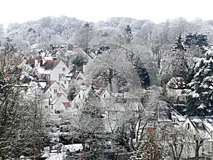 View across roof tops in the village of Chorleywood, Hertfordshire, UK in winter snow