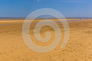 A view across the wide sandy expanse of Brancaster Beach, Norfolk, UK