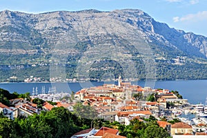 A view from afar looking down through the trees from a lookout of the beautiful ancient Croatian town of Korcula