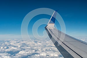 View of Aileron and Winglet of an aircraft wing over clouds