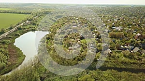 View from the air. fields and a country village by a small pond.