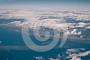 View from the airplane above the clouds over the coast of Croatia