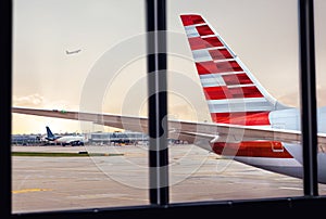 View of airplane fuselage tail through window at airport