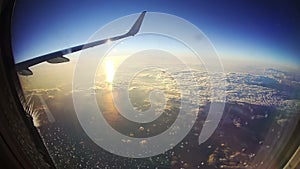 View from an Airplane Window above the Clouds on Sun Background