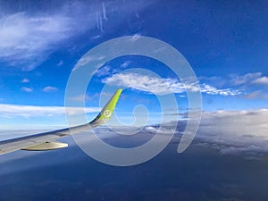 View from airplane window with blue sky and white clouds