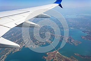 View from the airplane window. Clouds and landscape under the wing