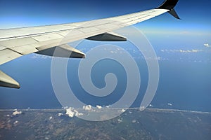 View through airplane window of commercial jet plane wing flying high in the sky. Air travelling concept