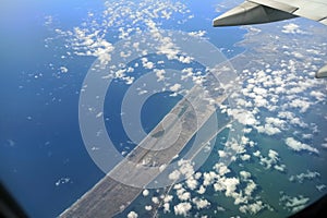 View through airplane window of commercial jet plane wing flying high in the sky. Air travelling concept