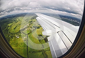 View from airplane window on green fields